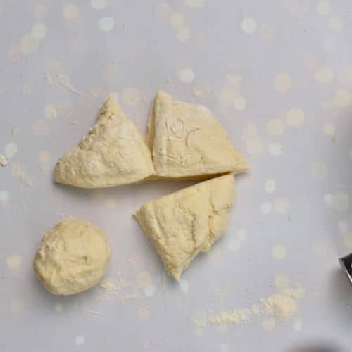 Cutting the 2-Ingredient Bagel dough into 4 pieces.