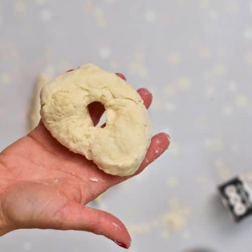 Rolling a piece of 2-Ingredient Bagel dough into a bagel shape.