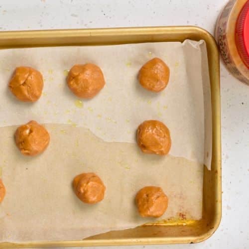 3-Ingredient Peanut Butter Cookie dough balls on a baking sheet.