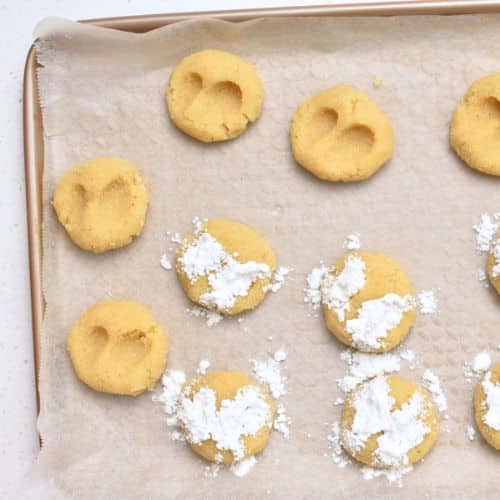 Adding powdered sugar on the Almond Cloud Cookies.