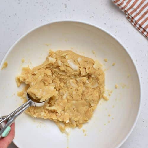 Forming Almond Flour Coconut Cookie dough balls with a cookie scoop.