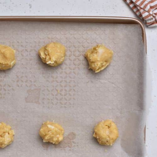 Almond Flour Coconut Cookie dough balls on a baking sheet.