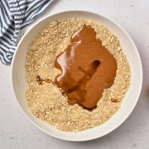 Adding liquid ingredients to the dry Almond Flour Oatmeal Cookie ingredients.