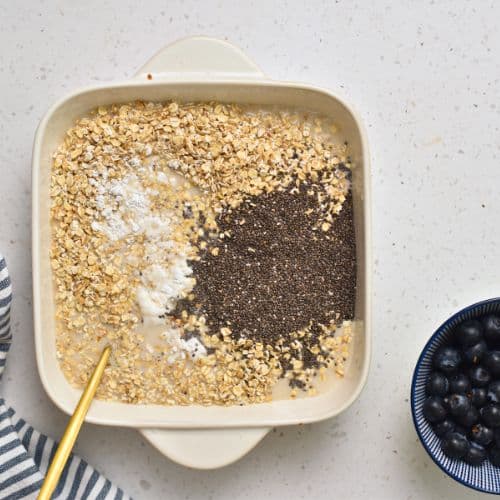 Adding all Baked Banana Blueberry Oatmeal ingredients to the pan.