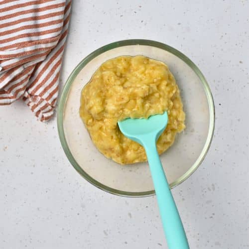 Mashing banana in a mixing bowl.