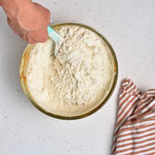 Adding flour to the Biscoff Banana Bread ingredients.