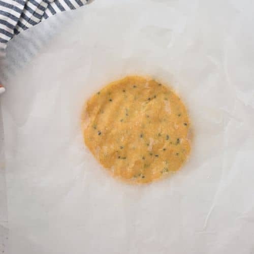 Flattening the Chickpea Cracker dough between parchment paper.