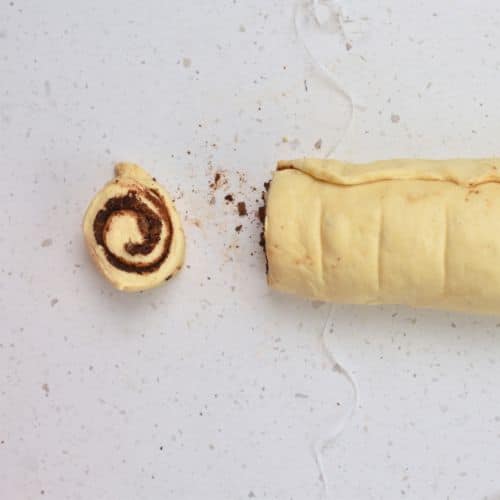 Cutting the Chocolate Cinnamon Rolls with dental floss.