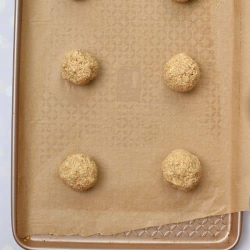 Crispy Oatmeal Cookie dough balls on a baking sheet.