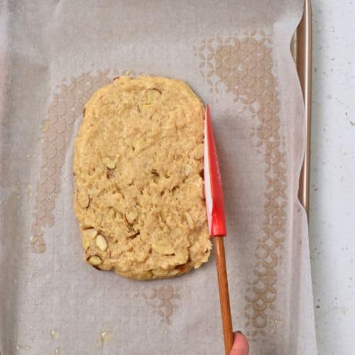 Shaping a Healthy Biscotti dough log on a baking sheet.