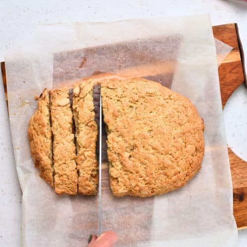 Slicing the Healthy Biscotti log after the first baking on a chopping board.