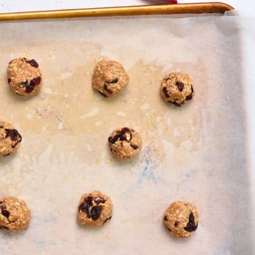 Healthy Oatmeal Cranberry Cookie dough balls on a baking sheet.