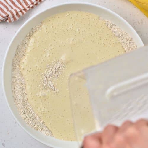 Pouring banana milk on the dry Healthy Pancake ingredients.