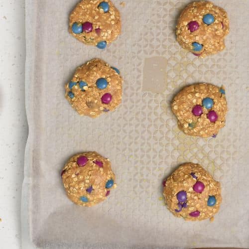 Healthy Monster Cookies ready to bake on a baking sheet.