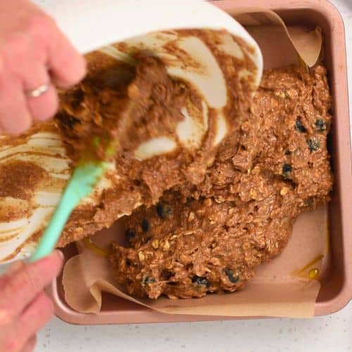 Pouring the Healthy Oatmeal Bar batter into a square pan.