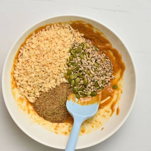 Adding dry Homemade Gluten-Free Granola Bar base ingredients to a bowl.