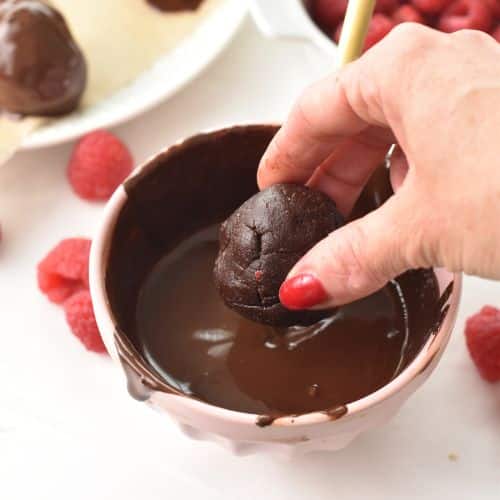 Dropping No-Bake Brownie Bites into melted chocolate.