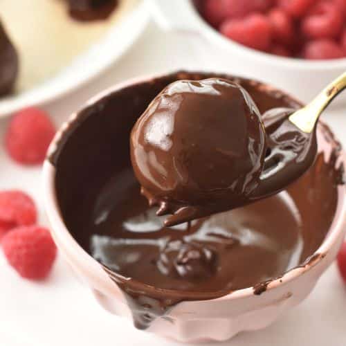 Dipping No-Bake Brownie Bites into a bowl with melted chocolate.