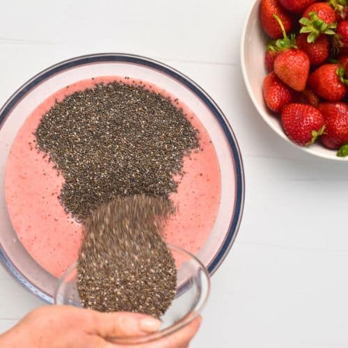 Adding chia seeds into the strawberry milk.