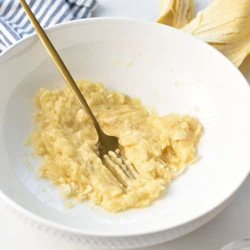 Mashed banana in a mixing bowl.