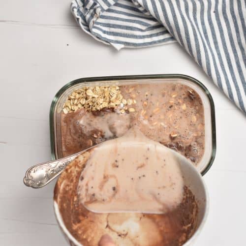 Adding the chocolate mixture to the Chocolate Overnight Oats base.