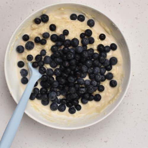 Incorporating blueberries into the dough.