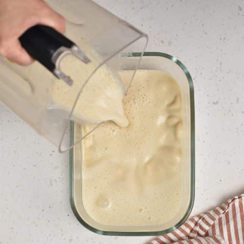 Pouring peanut butter milk into a container.